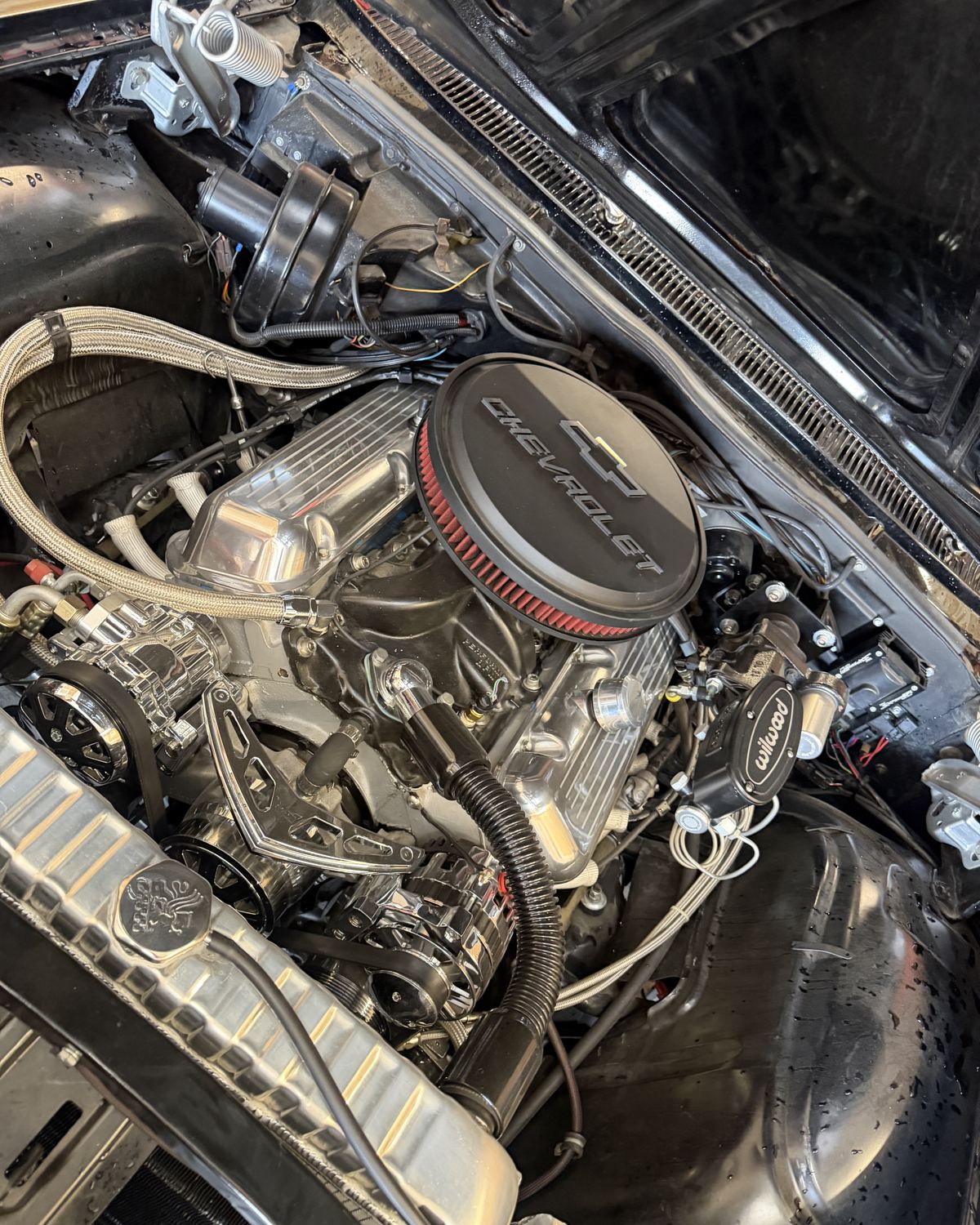 A Chevrolet V8 with a chrome air cleaner under the hood of a classic car at Ronnie’s Automotive